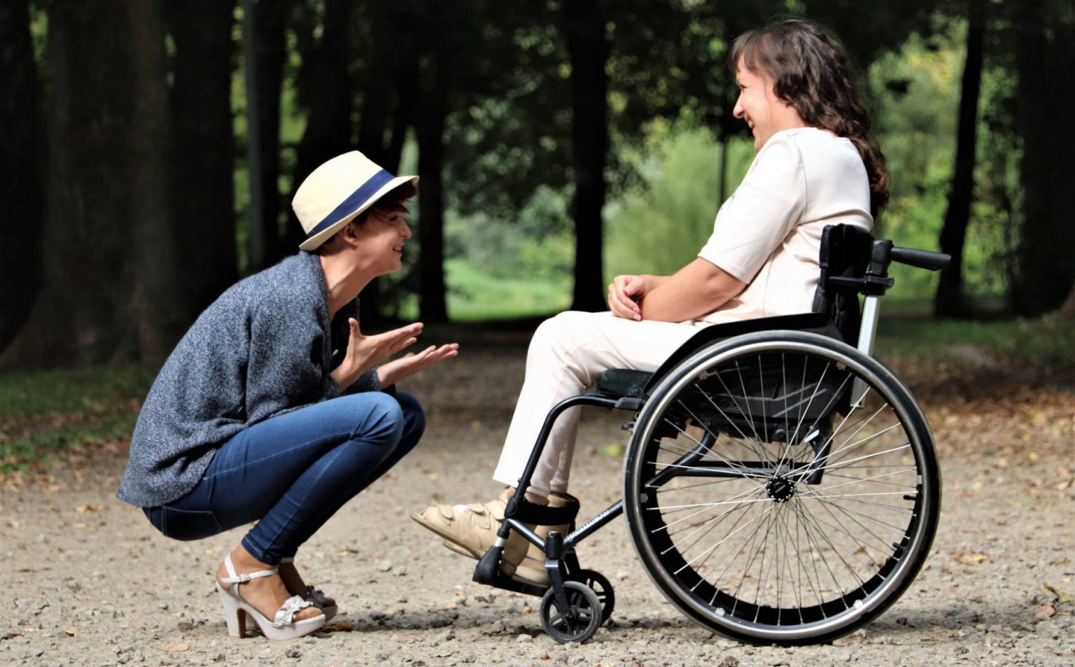 Personne parlant avec une autre personne en fauteuil roulant